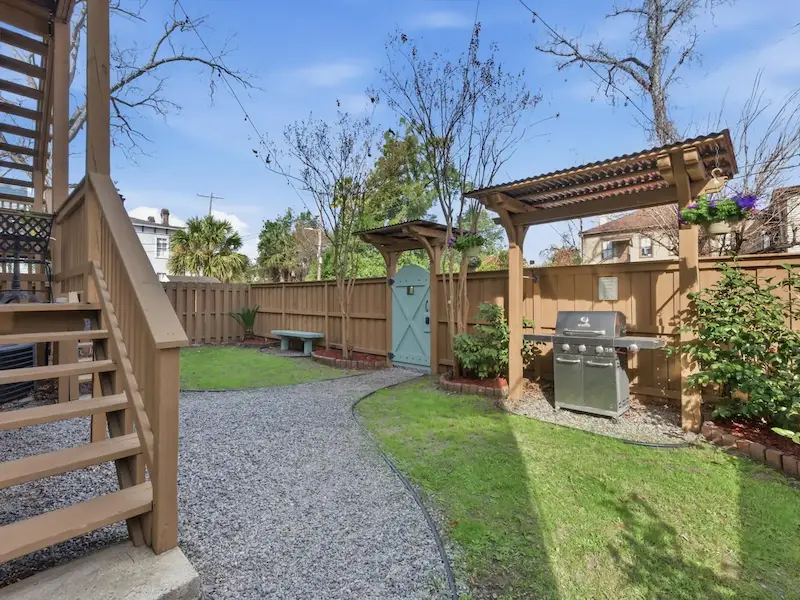 Suite 314A backyard with gas grill at Savannah vacation rental — pergola green lawn private outdoor space
