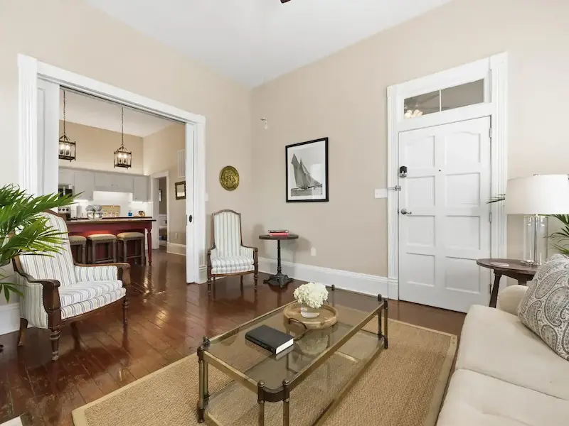 Suite 314A historic Savannah living room — soaring ceilings, heart-pine floors, and palms