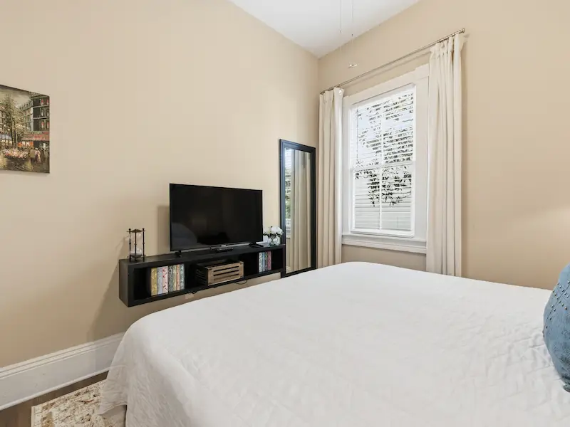 Suite 314A king bedroom Victorian District Savannah rental — sailboat art closet hardwood floors