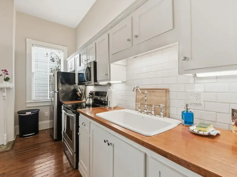 Suite 314A Savannah Airbnb kitchen — butcher block wood countertops subway tile backsplash farmhouse sink