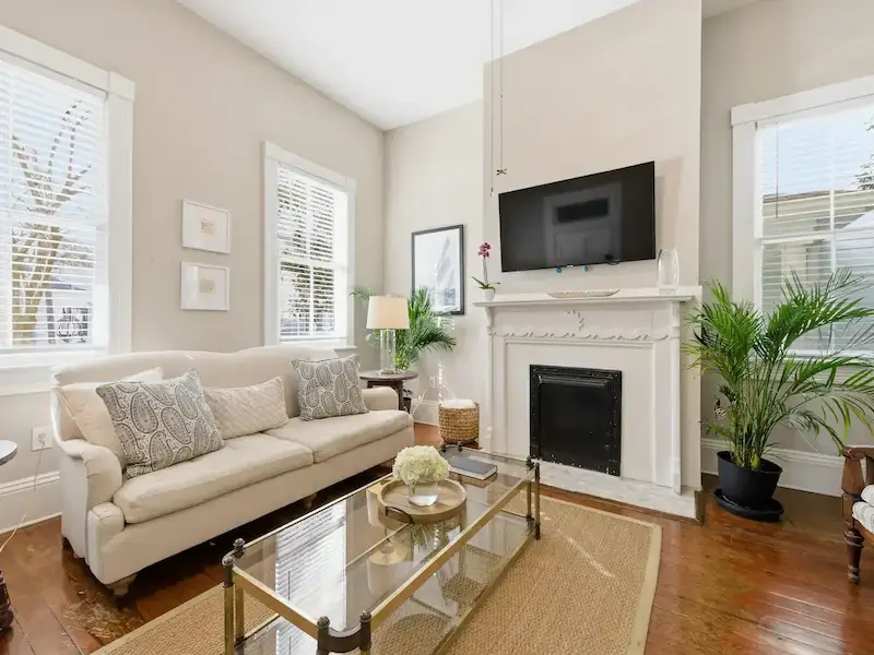 Suite 314A living room at The Wilder House — original heart-pine floors and striped chairs with view to kitchen island
