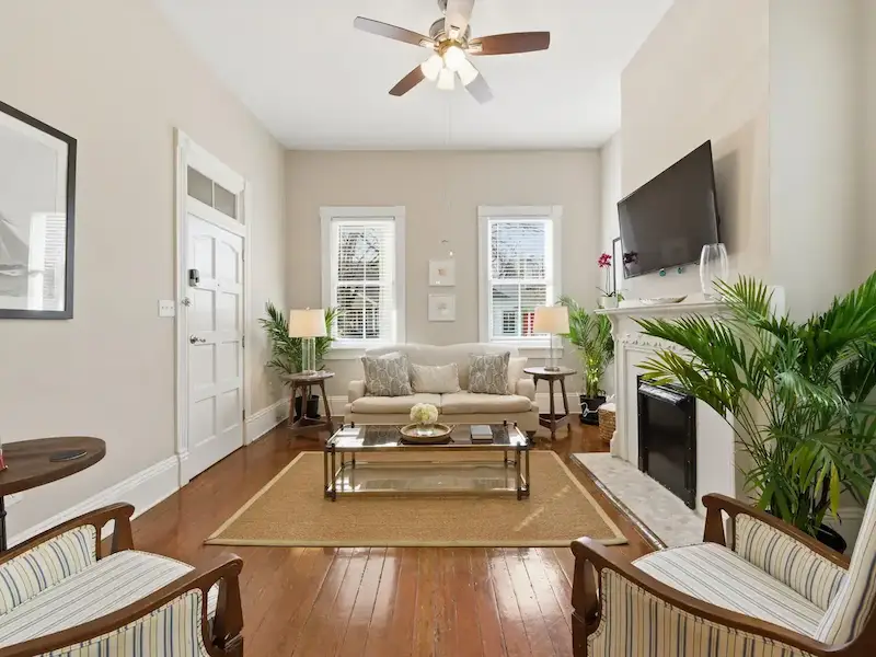 Suite 314A Victorian District Savannah living room — cream sofa, glass coffee table and ornate Victorian millwork