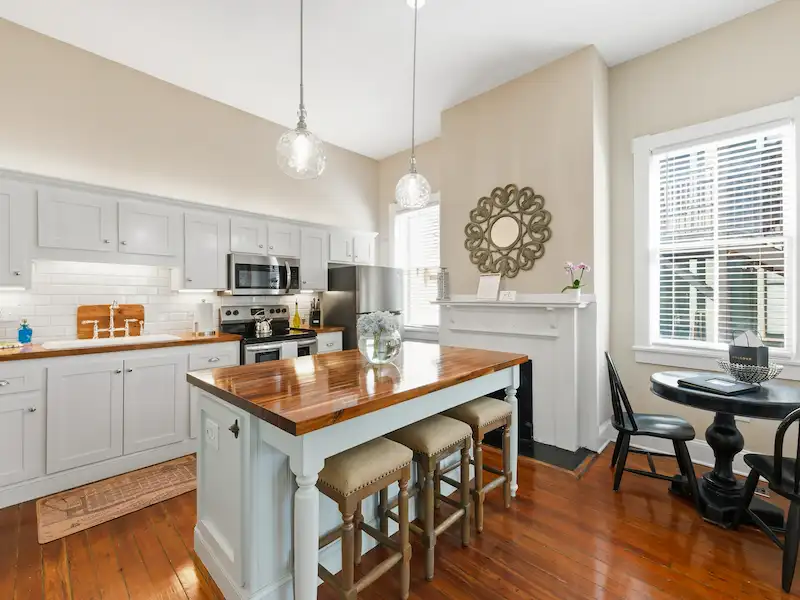 Suite 316A kitchen with haint blue island and pendant lights — Victorian District Airbnb Savannah
